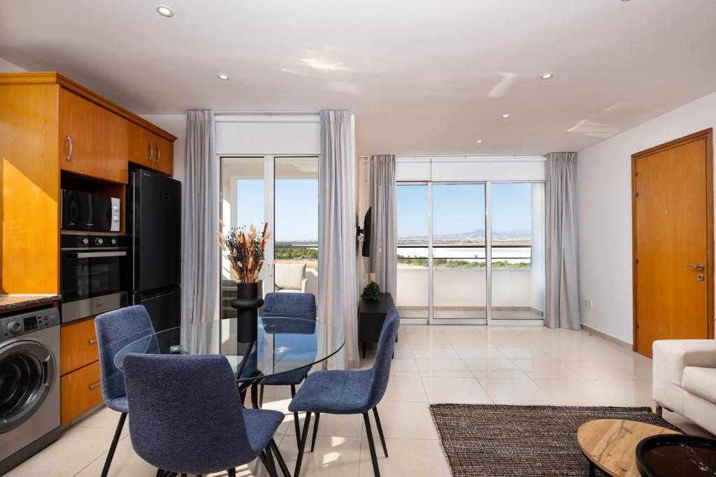 拉納卡的住宿－The Saline Views Makenzy，客厅配有玻璃桌和蓝色椅子
