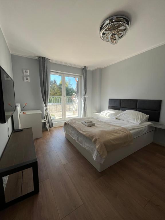 1 dormitorio con cama y ventana grande en comfy guest Apartment, en Varsovia