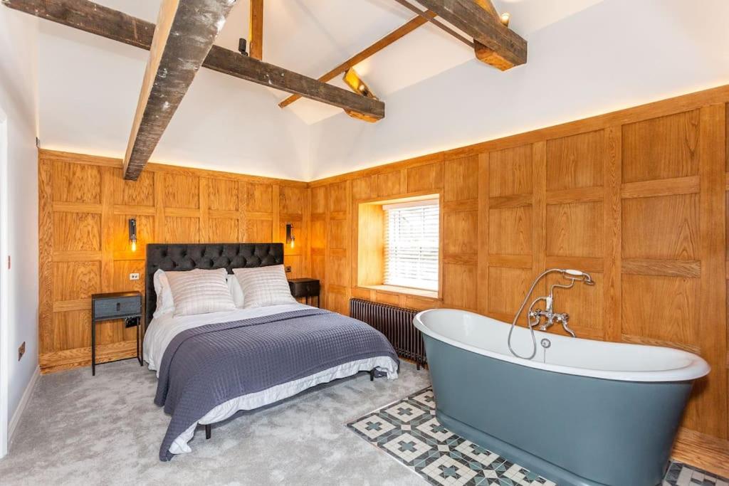 a bedroom with a bed and a bath tub at Forrester Cottage, Masham, North Yorkshire in Masham