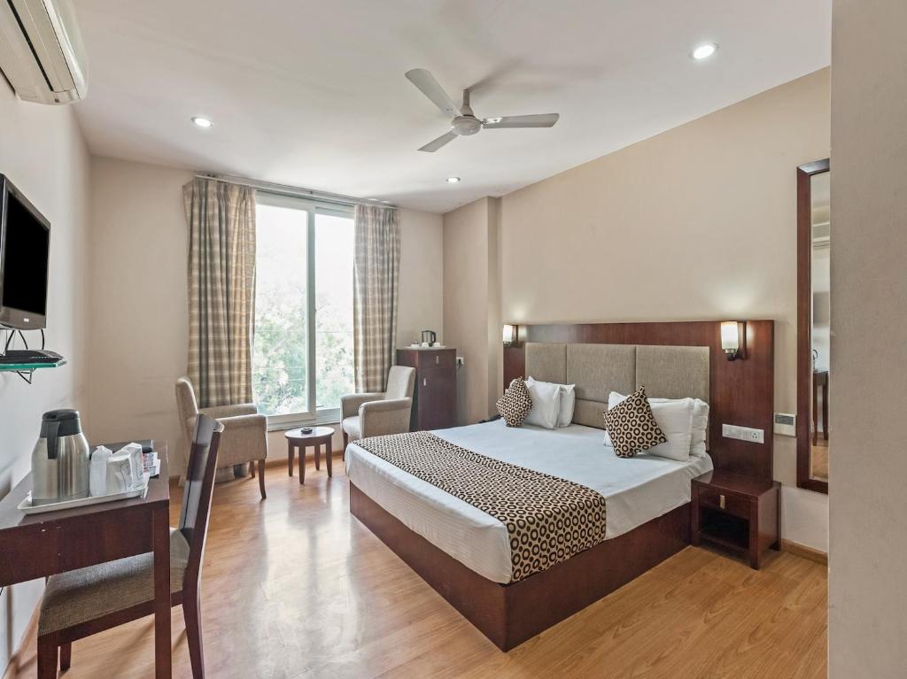 ein Schlafzimmer mit einem Bett und einem Schreibtisch sowie ein Zimmer in der Unterkunft Hotel Royal Palm - A Budget Hotel in Udaipur in Udaipur