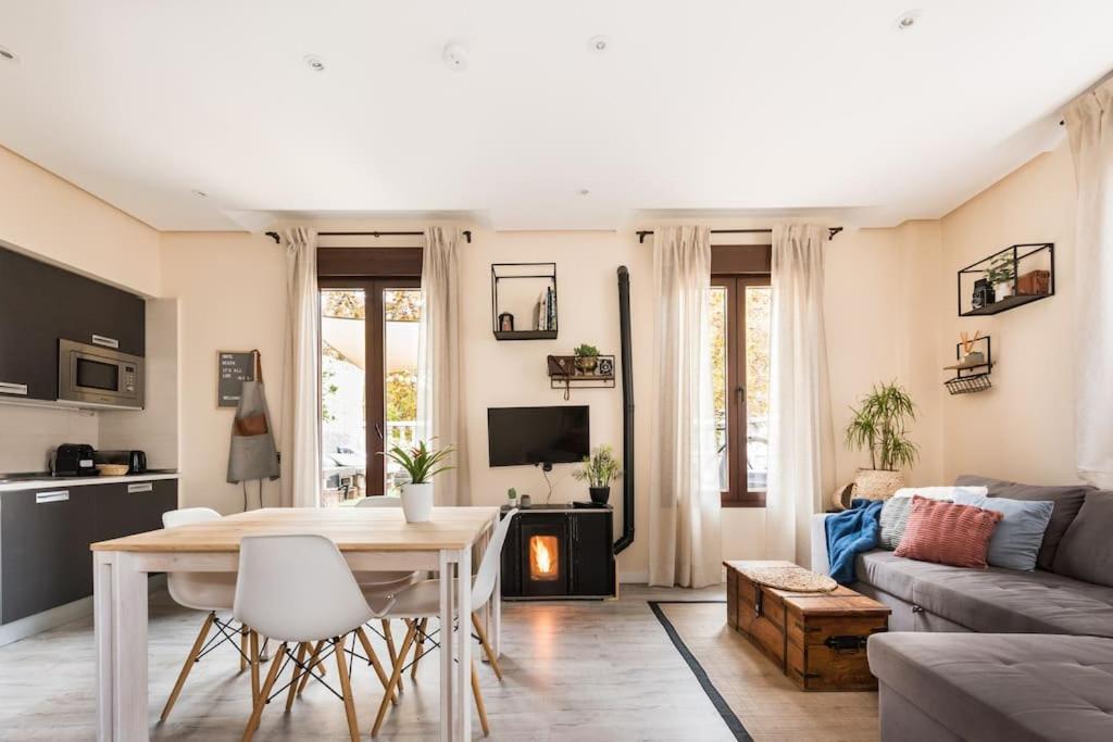 a living room with a table and a couch at Ático con terraza y chimenea junto a Universidad in Alcalá de Henares