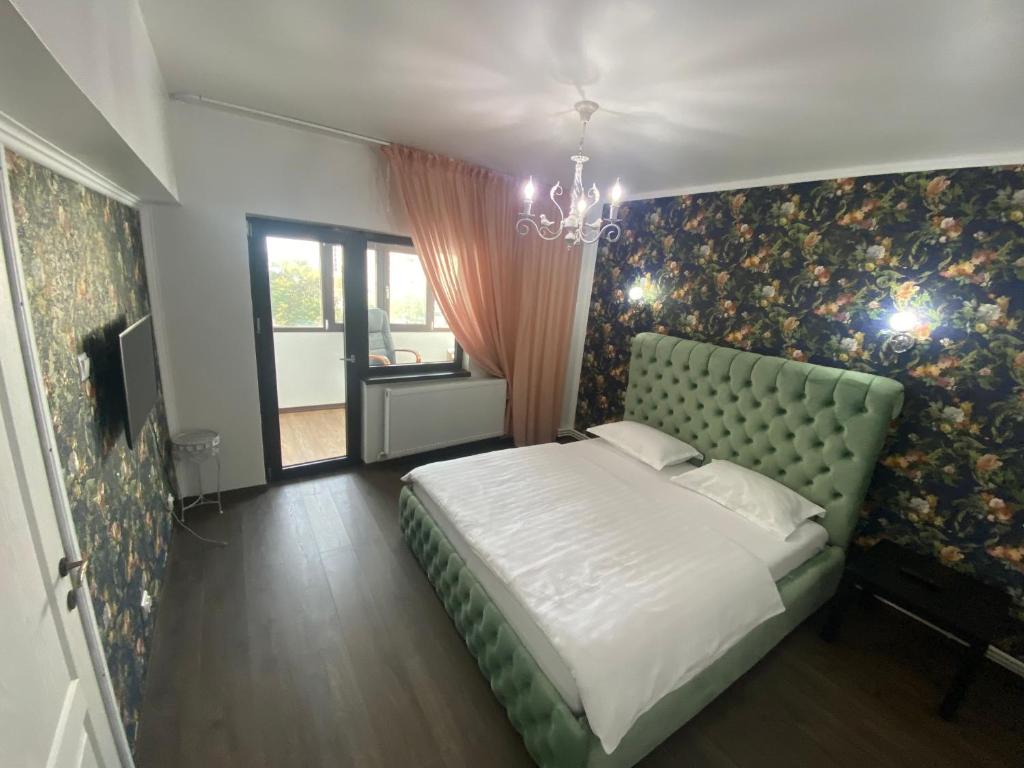 a bedroom with a bed and a wall with flowers at Violetta Apartament in Buzău