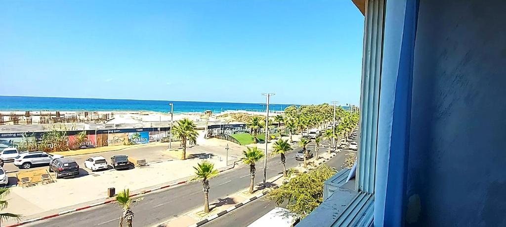 een uitzicht vanuit een raam van een straat met een parkeerplaats bij Short Term Apartment Tel Aviv Bat Yam 413 in Bat Yam