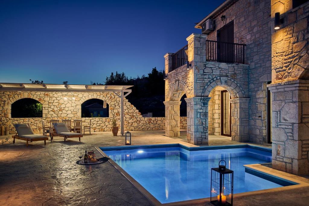 Maryiés的住宿－Ioanna Château - Luxury Stone Villa，庭院中间的游泳池