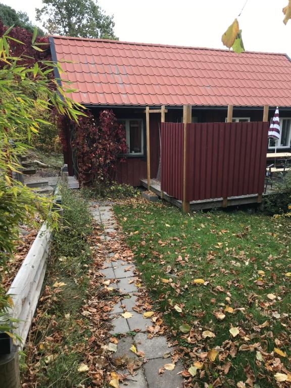 dom z czerwonym dachem i dziedzińcem w obiekcie Trevlig stuga på landet, centralt 8km från Centrum w mieście Eskilstuna