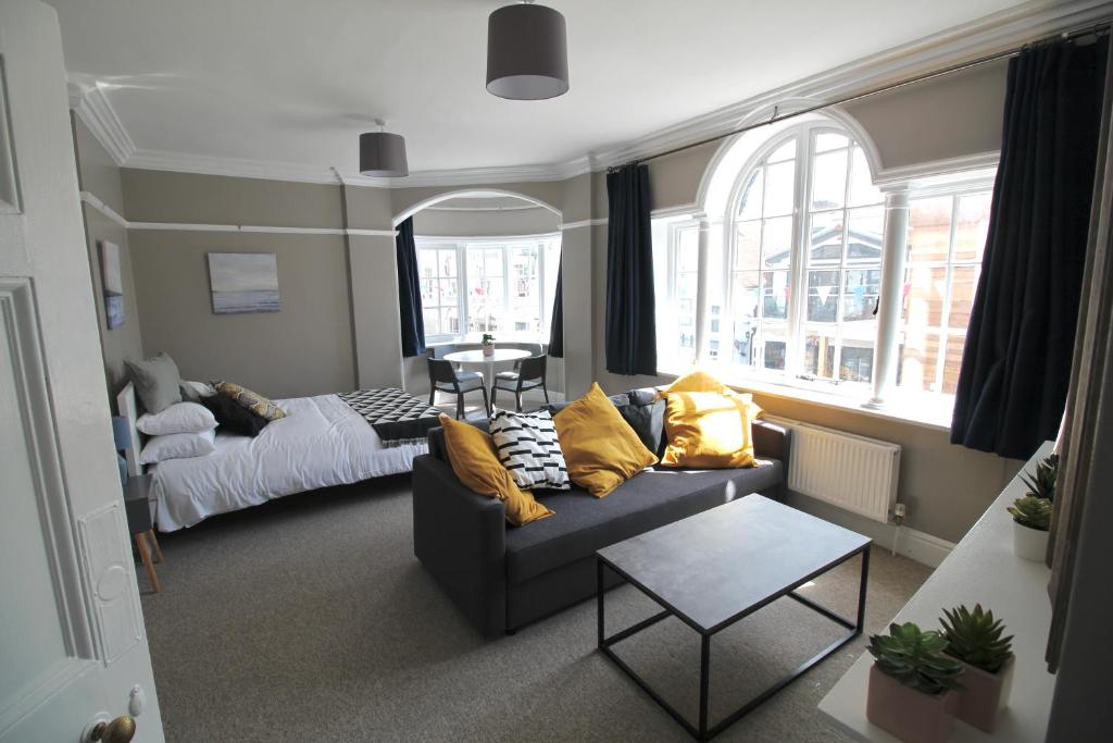 a living room with a couch and a bed at Pier View Studio Apartment in Cowes
