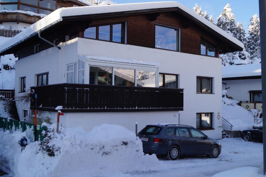 um carro estacionado em frente a uma casa na neve em Haus Meinrad em Seefeld no Tirol