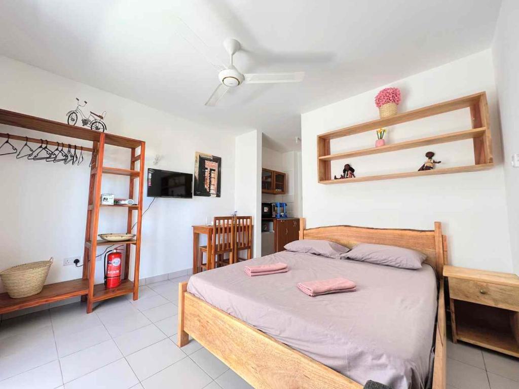 a bedroom with a bed with two pink towels on it at Homerent @ Fumba-Town in Dambani