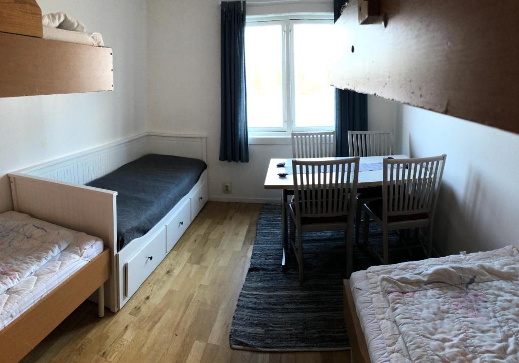 um quarto com uma cama, uma mesa e cadeiras em Allégården Kastlösa Vandrarhem em Kastlösa