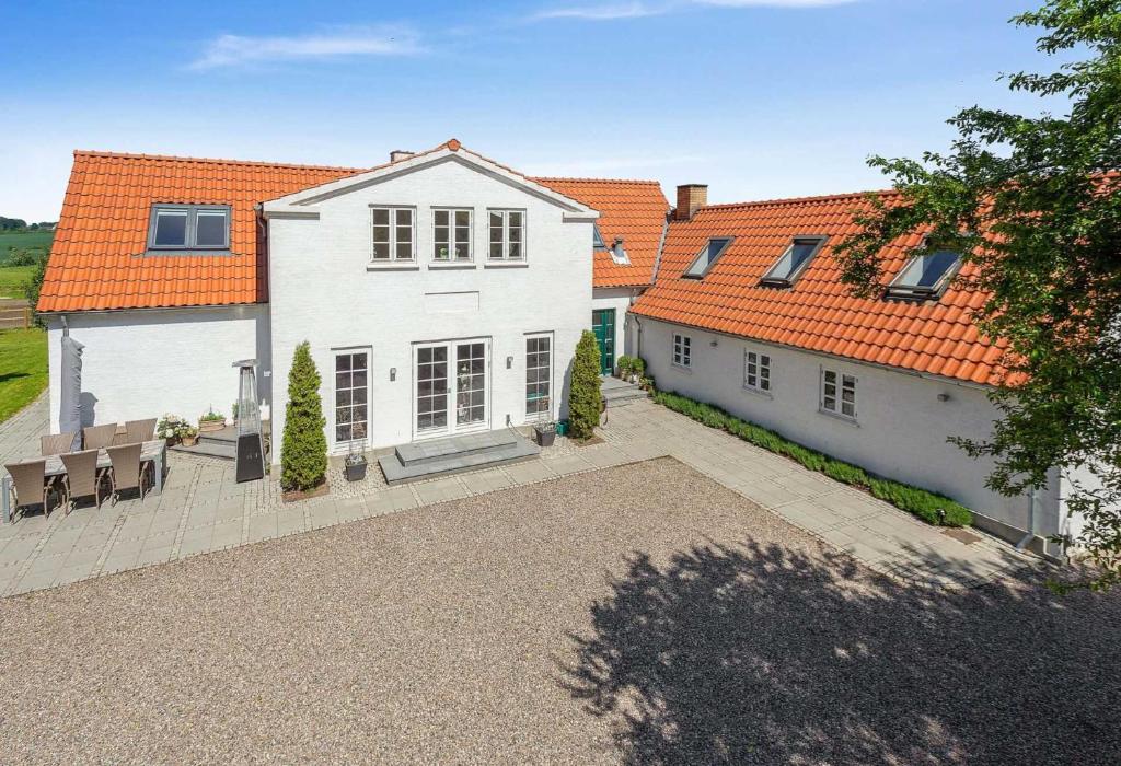 uma grande casa branca com um telhado laranja em Farmens Gæstehus em Svebølle