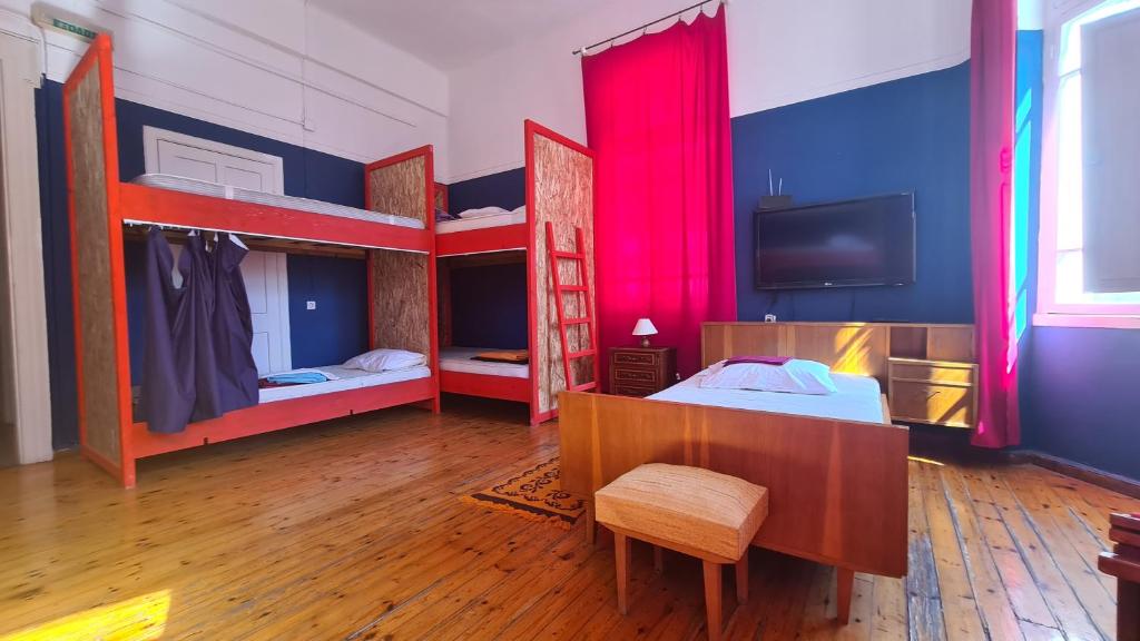 a room with three bunk beds and a tv at Doukas Hostel Room in Heraklio Town