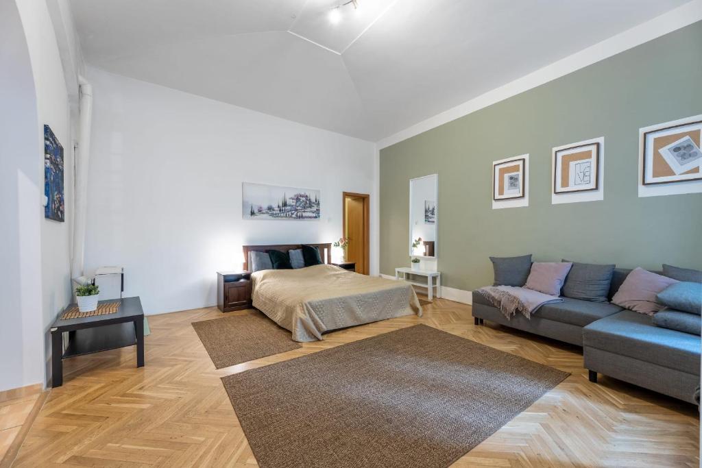 a living room with a bed and a couch at Spacious 3 bedroom apartment in the Heart of Prague in Prague
