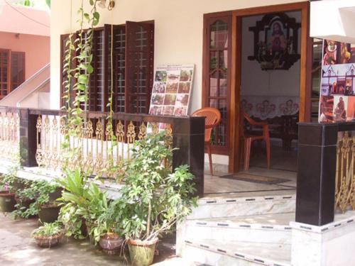a porch of a house with potted plants at Prems Homestay in Cochin