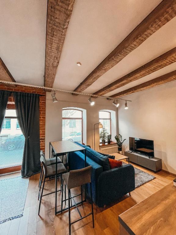 a living room with a blue couch and a table at 1880 Apartment with Private Parking in Marijampolė