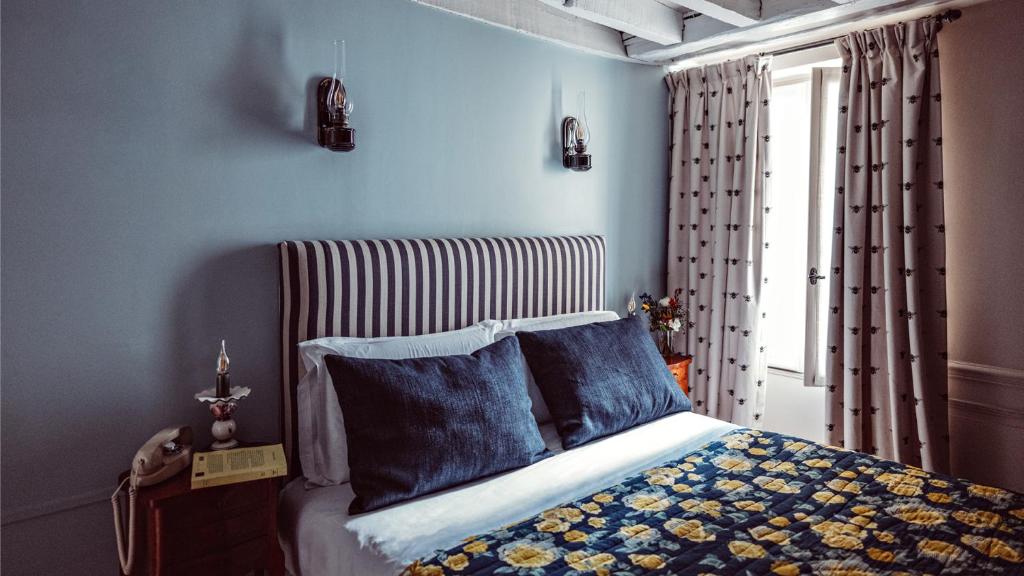 a bedroom with a bed with blue walls and a window at Maison Saintonge in Paris