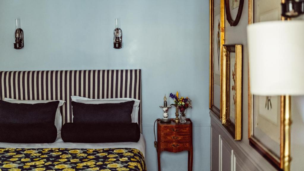 a bedroom with a bed and a mirror and a lamp at Maison Saintonge in Paris