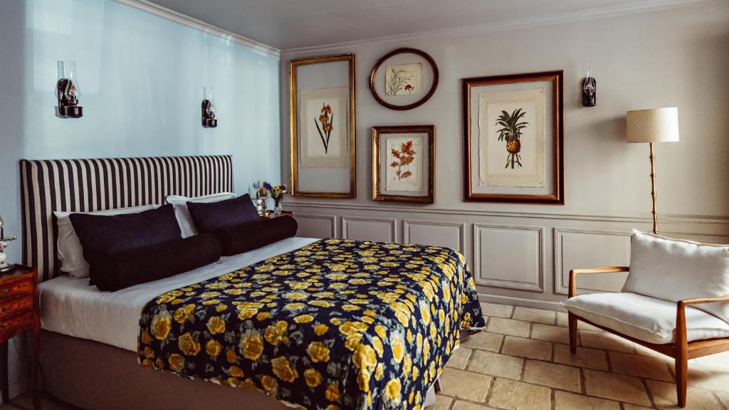 a bedroom with a bed and a chair and a clock at Maison Saintonge in Paris
