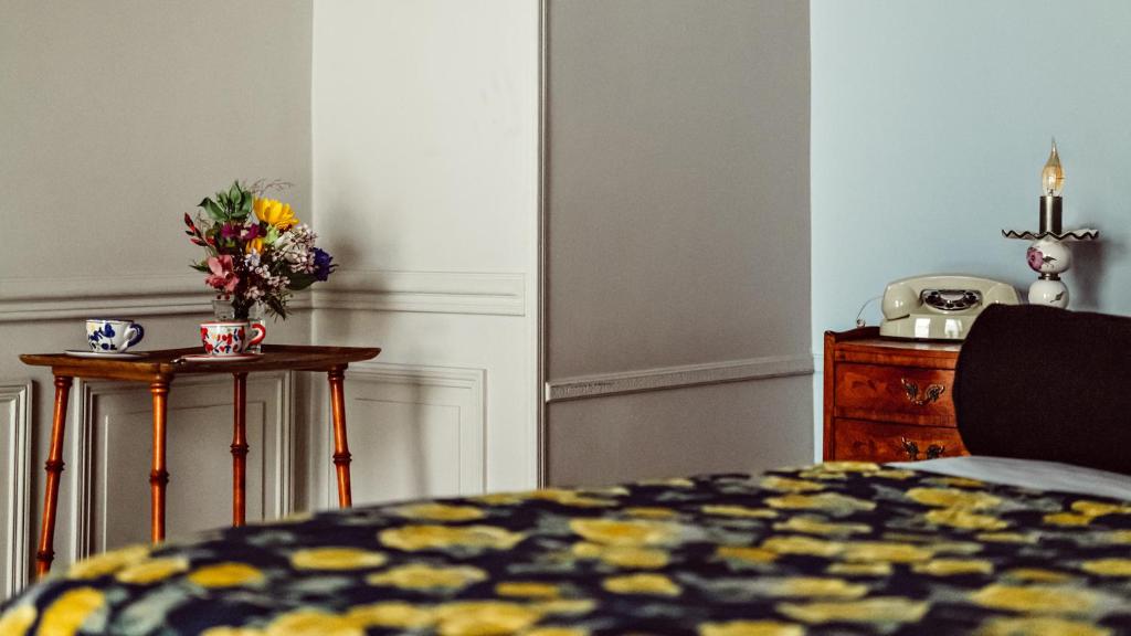 a bedroom with a bed and a table with a telephone at Maison Saintonge in Paris