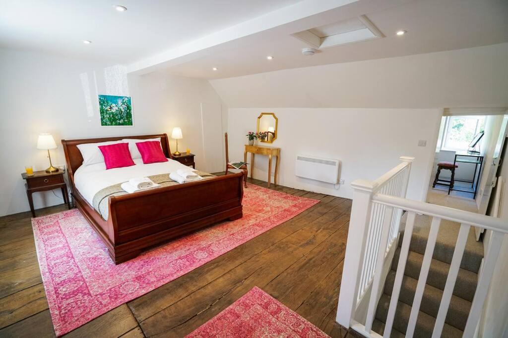 a bedroom with a bed and a pink rug at Number Five in Earl Soham Suffolk 