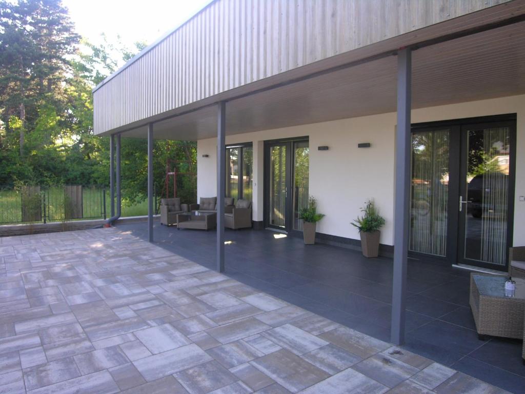eine Terrasse mit Glastüren und ein Gebäude in der Unterkunft Apartments in Balatonlelle 43116 in Balatonlelle