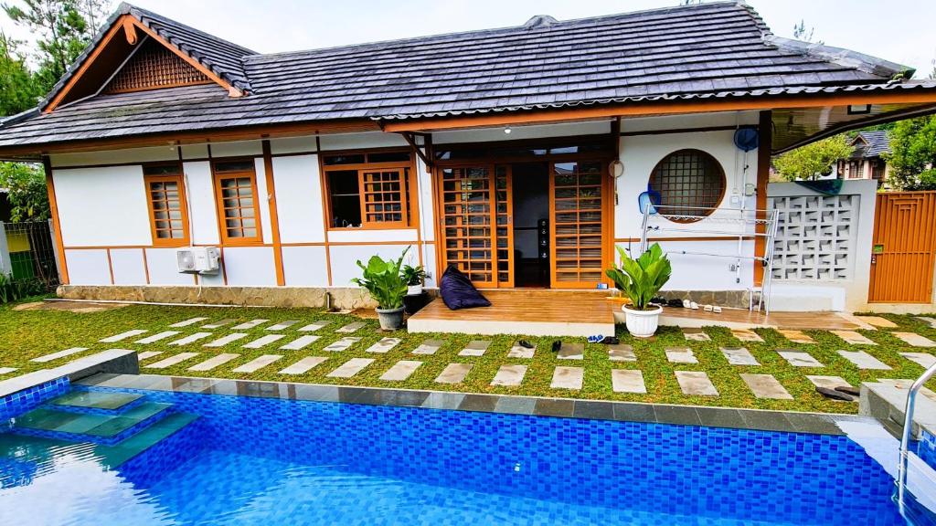 a house with a swimming pool in front of it at SF Homey Yokohama in Cikundul