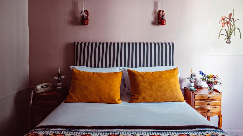 a bedroom with a bed with yellow pillows at Maison Saintonge in Paris