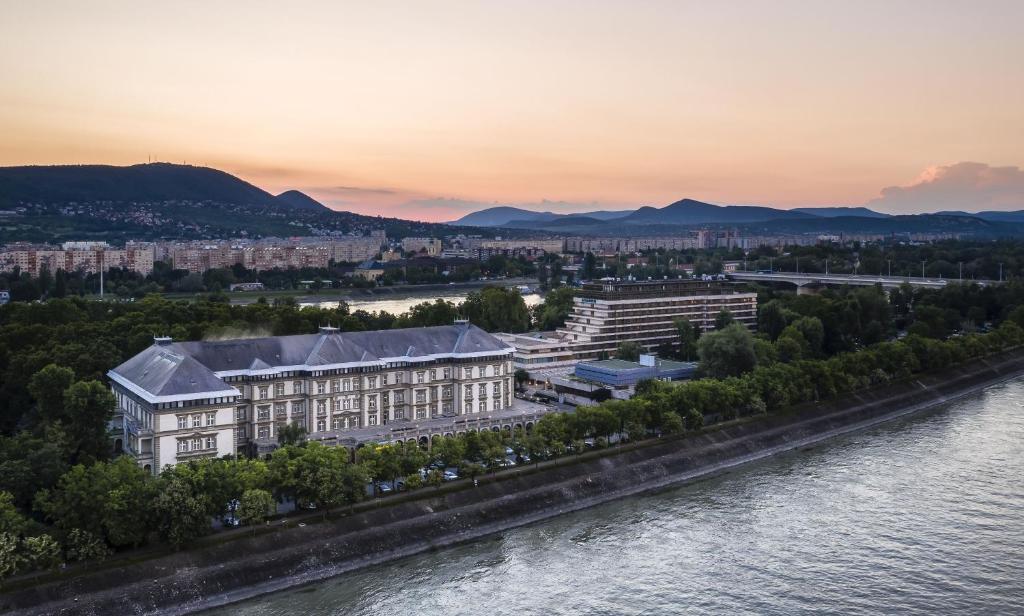 eine Luftansicht eines Gebäudes neben einem Fluss in der Unterkunft Ensana Grand Margaret Island in Budapest