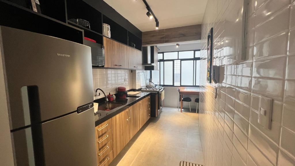 a kitchen with a stainless steel refrigerator and a sink at Beira Mar na José Menino in Santos