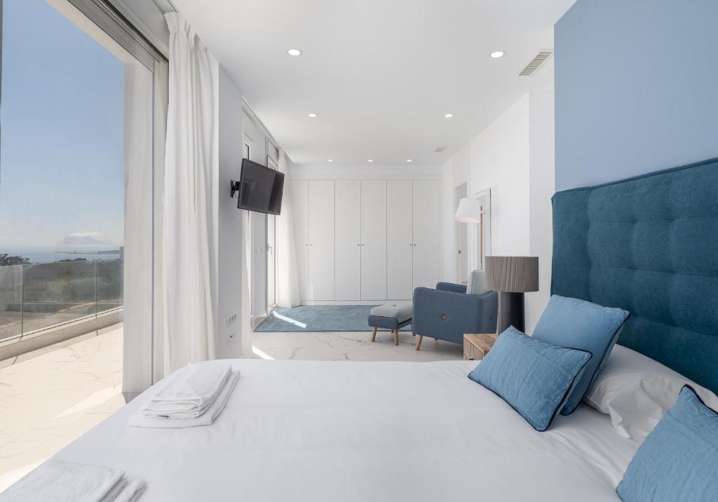 sypialnia z dużym łóżkiem i dużym oknem w obiekcie Villa Eliseo - private pool and sea views I 2400 w mieście San Roque