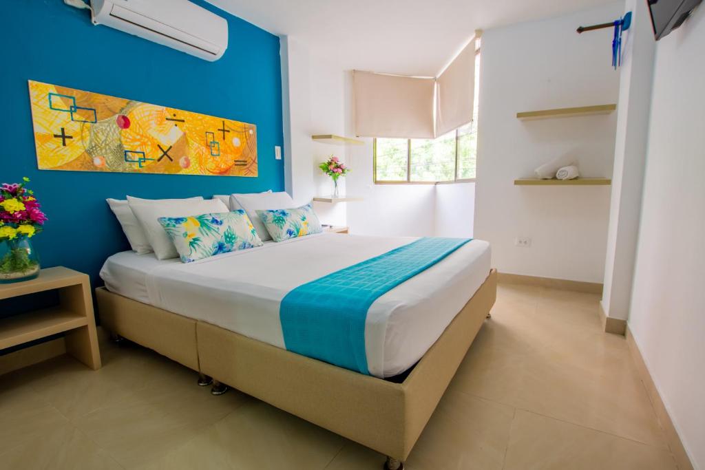 1 dormitorio con 1 cama con pared azul en Taybo Beach By St Hoteles, en Santa Marta