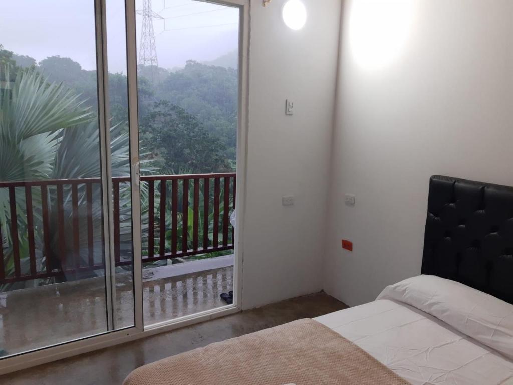 a bedroom with a bed and a balcony with a view at Deep Forest Posadas Ecoturisticas in El Zaino