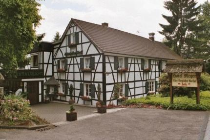 a black and white house with a sign in front of it at Hotel Meyer in Kürten