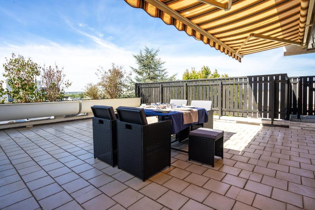 a patio with a table and chairs on a roof at Les Terrasses de la Vallée in Champs-Sur-Marne