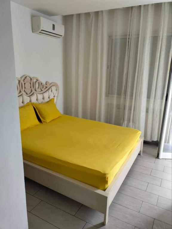 a bed in a room with a yellow sheets and pillows at Super Chiraz Loft in Nabeul
