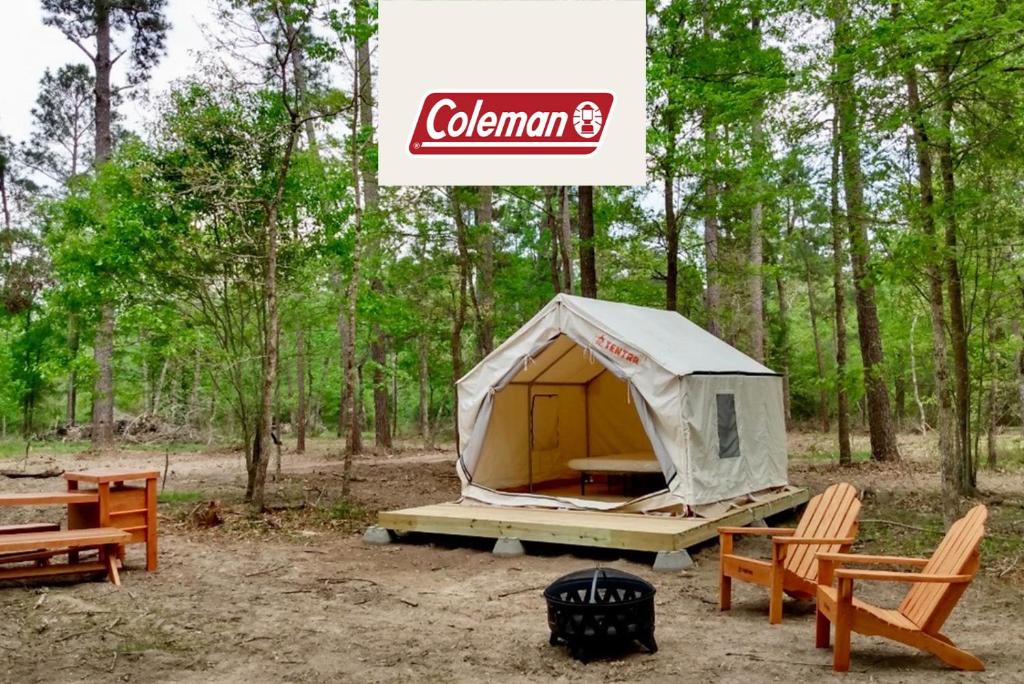 a tent in the woods with chairs and a grill at Tentrr Signature Site - Hidden Forest in Montgomery