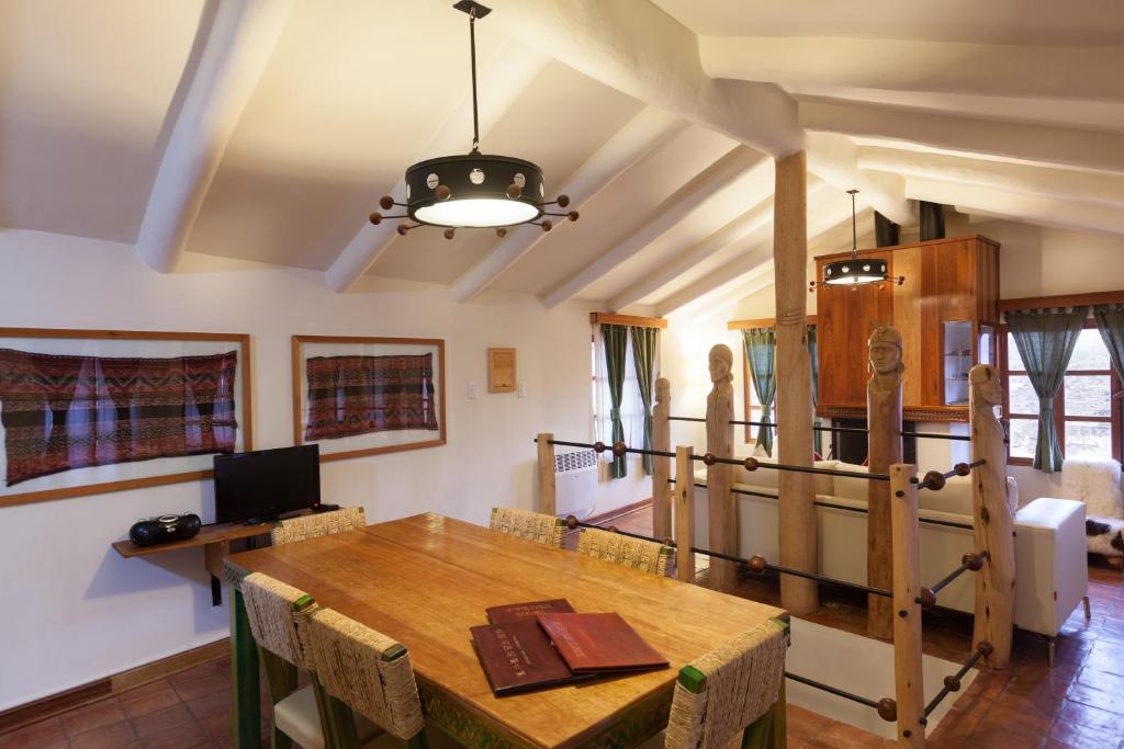a dining room with a wooden table and chairs at Quinua Boutique Apartments in Cusco