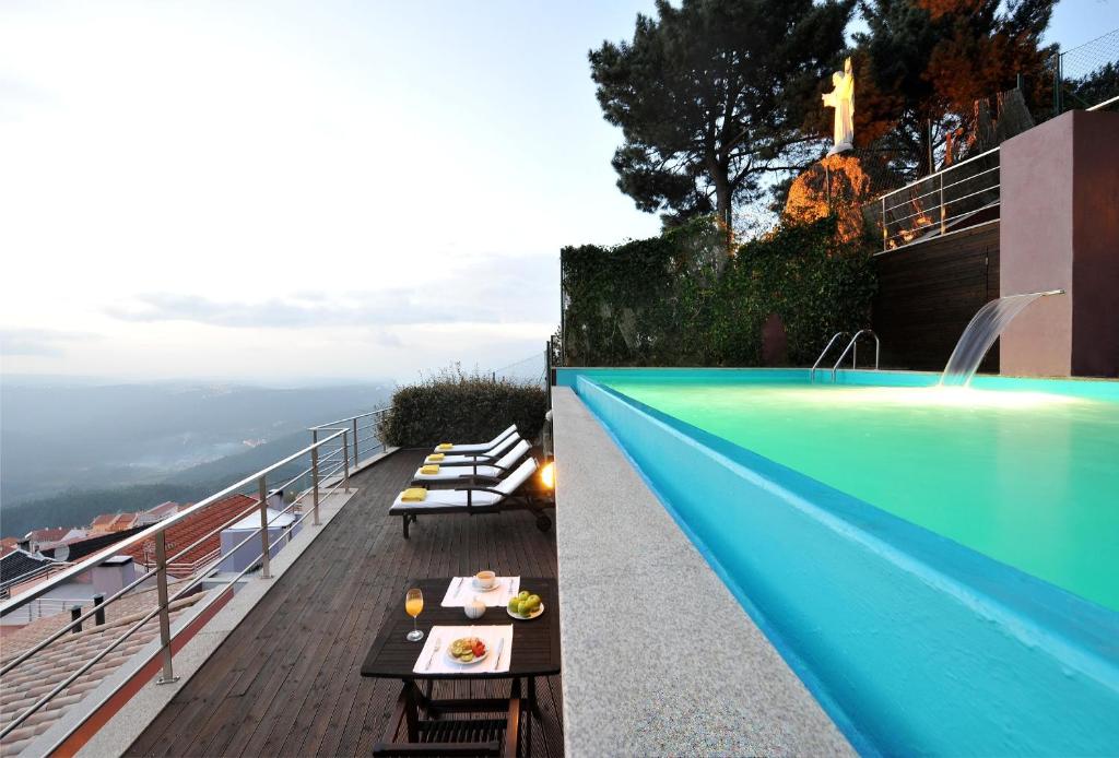 a pool on top of a building with a view of the ocean at Casas do Soito in Seia
