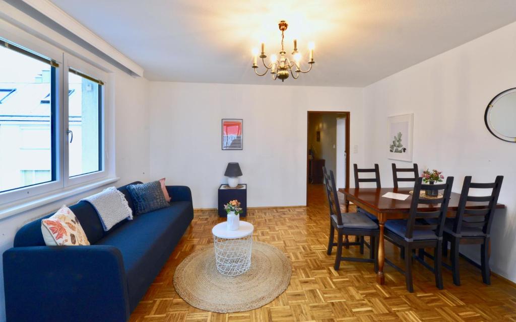 ウィーンにある3-Bedroom-Flat With Parking Spaceのリビングルーム(青いソファ、テーブル付)