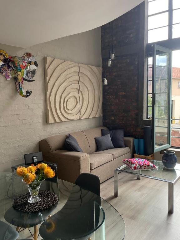 a living room with a couch and a glass table at Loft Apartment Cape Town The Waterkant in Cape Town