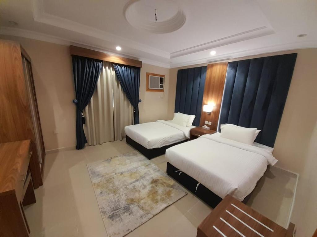 a hotel room with two beds and a rug at واحة طيبة للشقق الفندقية in Al Madinah