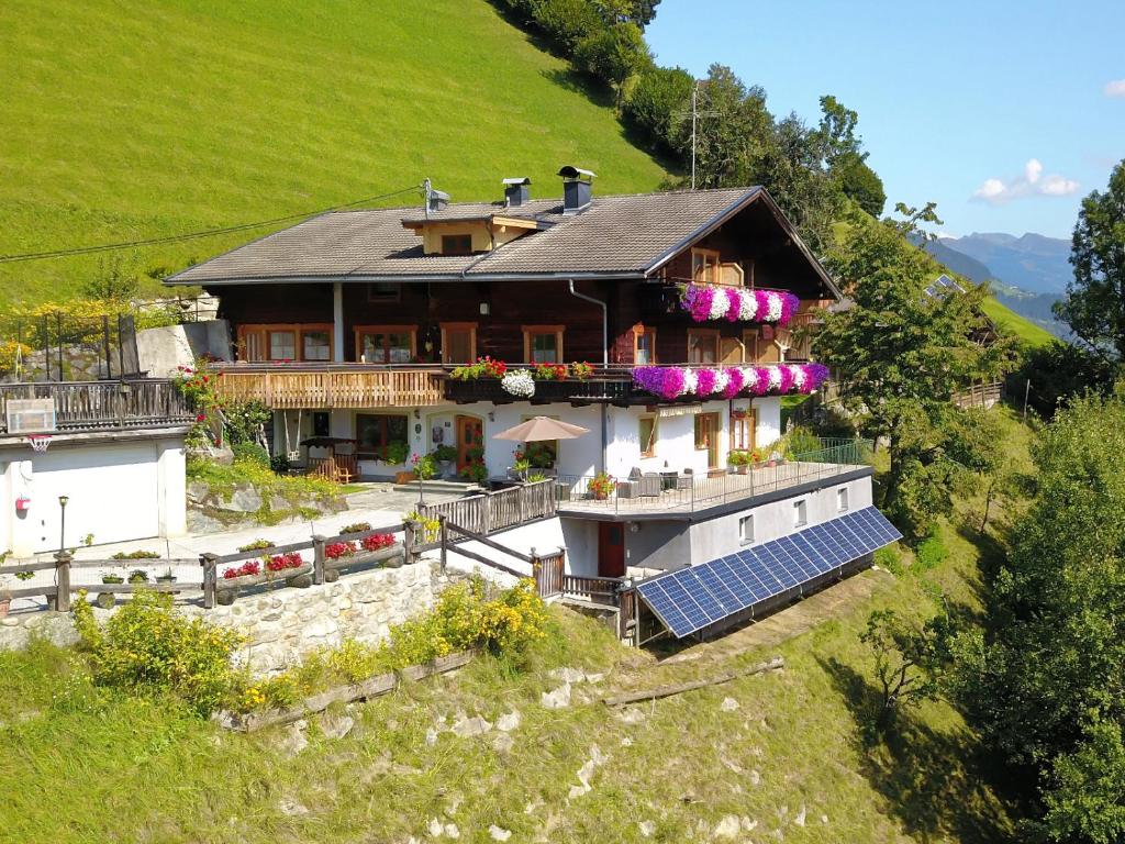 Una casa en una colina con paneles solares. en Ferienwohnungen Birkleiten, en Bramberg am Wildkogel
