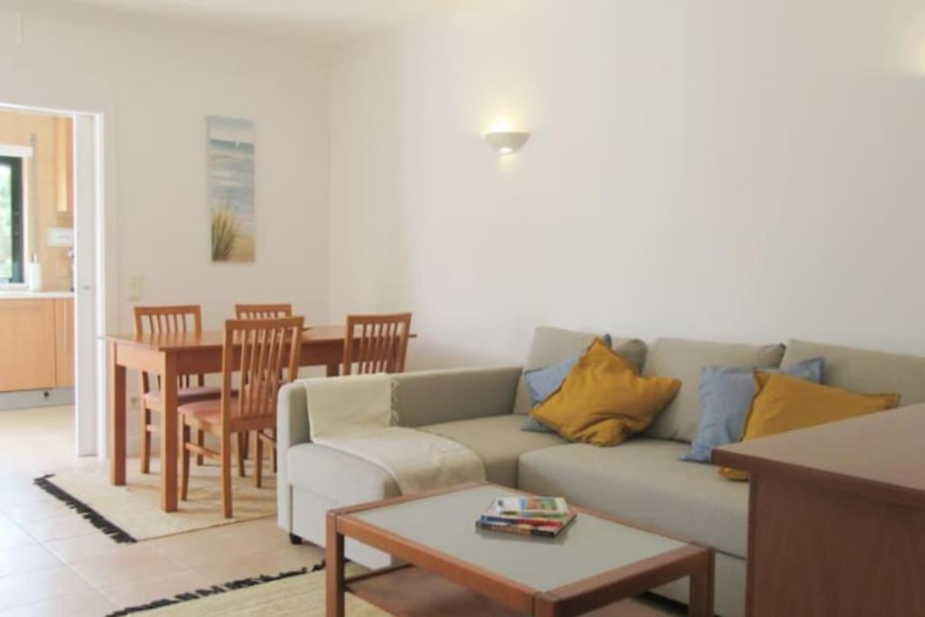 uma sala de estar com um sofá e uma mesa em Cosy flat, Salgados Village na Guia