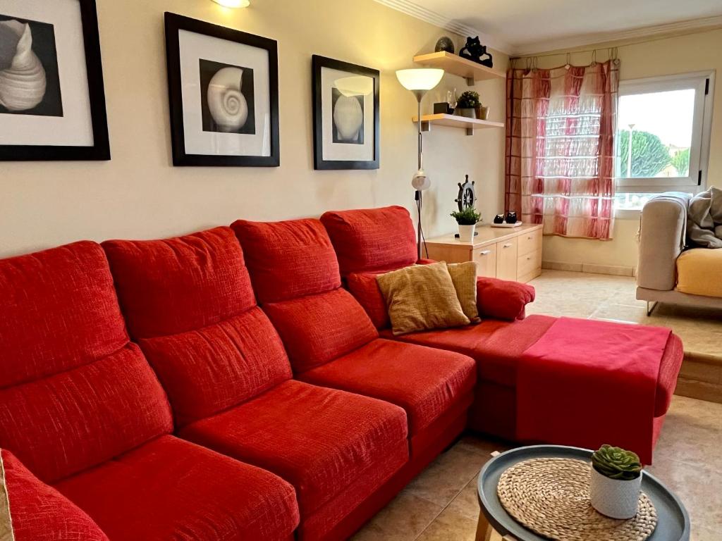 a red couch in a living room at Las Nasas, Acogedor apartamento cerca de la playa in Arinaga