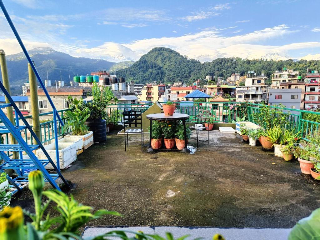 a balcony with a table and potted plants at R&R Guest House in Pokhara