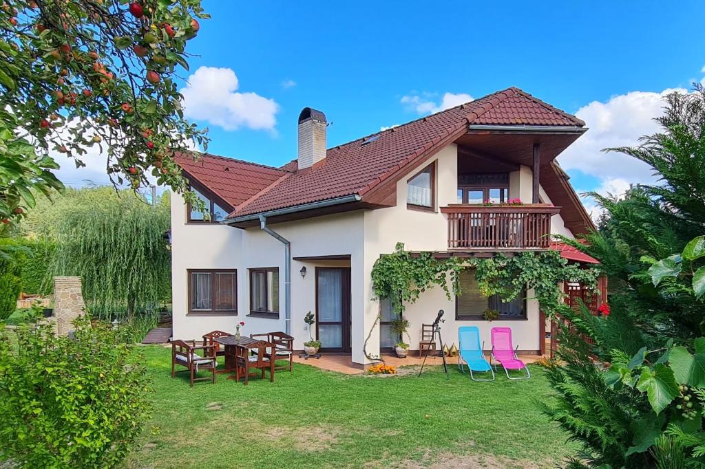 a house with chairs and a table in the yard at Clara Valis - Village House in Doľany