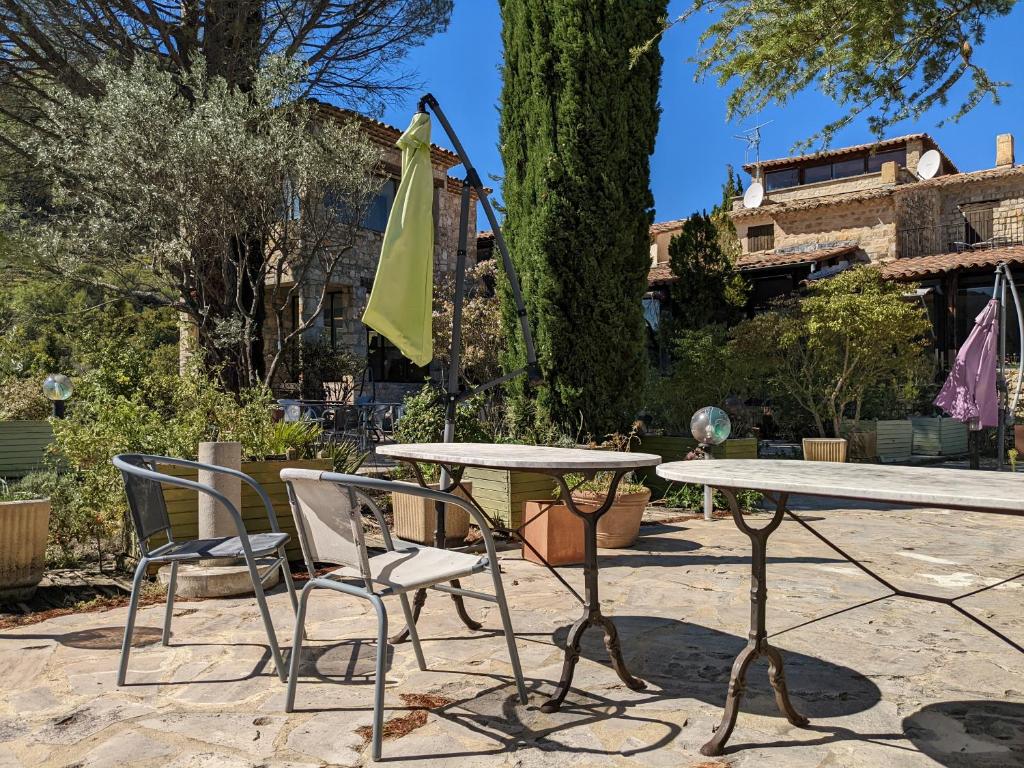a table and two chairs and a table with an umbrella at Les Colombes in Aubres