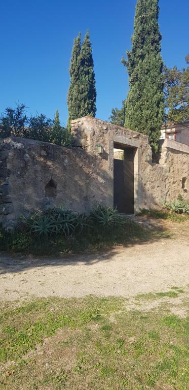 uma parede de pedra com uma porta num quintal em Gite fabuleux Saint Michel em Muro