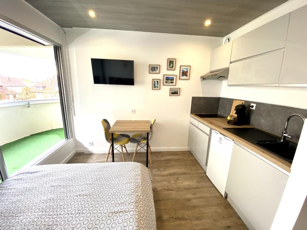 eine Küche mit einem Tisch und eine kleine Küche mit einem Fenster in der Unterkunft Le moulin vieux in Pontarlier