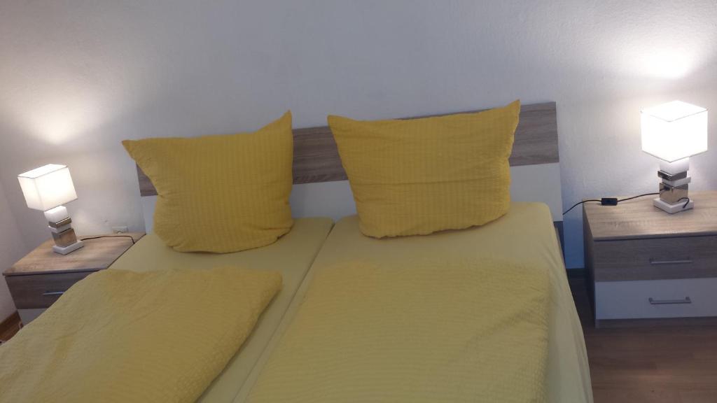 エーベルバッハにあるFerienhaus Eberbachのベッドルーム1室(黄色いシーツとランプ2つ付)