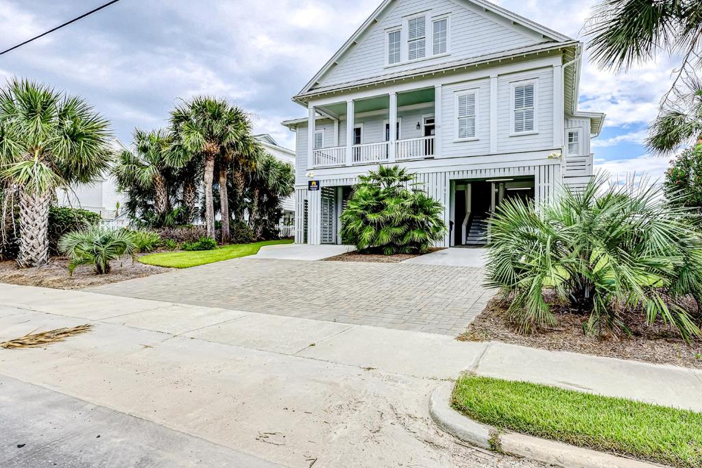 Una casa blanca con palmeras y un camino de entrada. en Ocean Elegance, en Edisto Beach